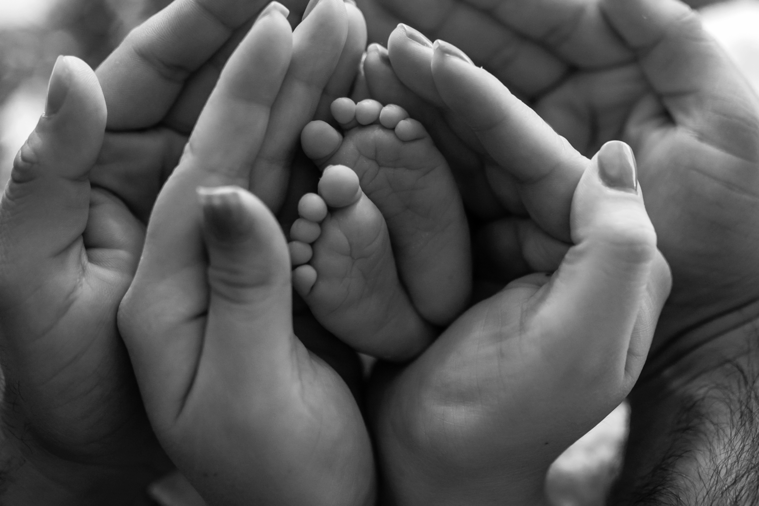 a mão do pai e da mãe e os pezinhos de bebê